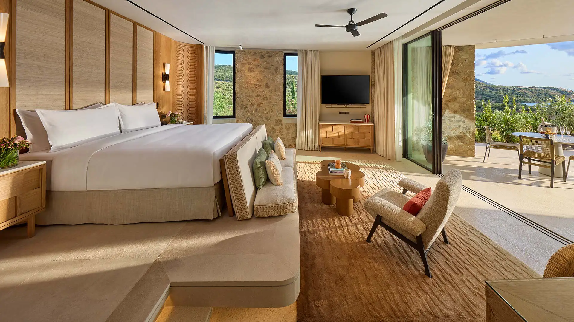 Πολυτελές υπνοδωμάτιο ξενοδοχείου με θέα στη βεράντα και το φυσικό τοπίο