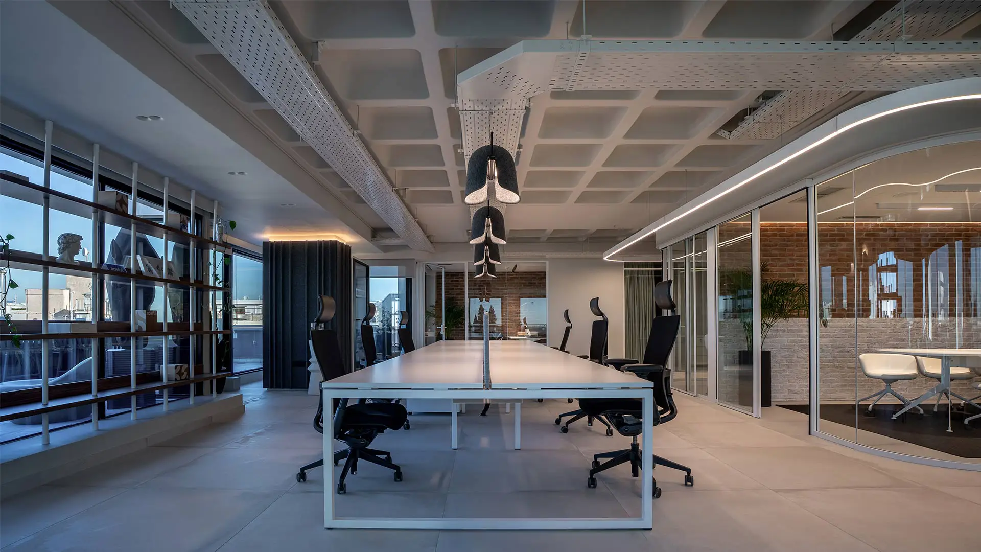 Σύγχρονος επαγγελματικός χώρος γραφείων με μεγάλο τραπέζι συνεργασίας και γυάλινα διαχωριστικά
